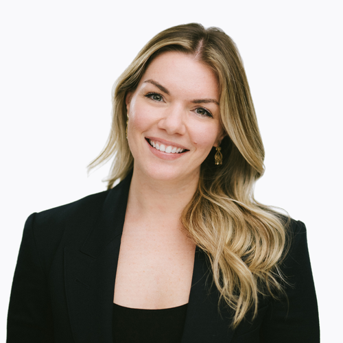 A smiling woman with blonde hair wearing a black blazer.