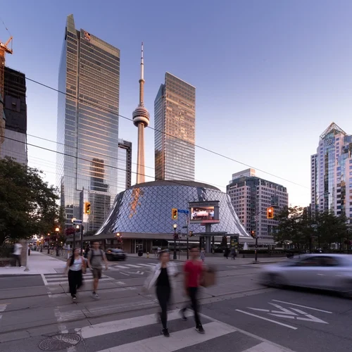 The CN Tower and Roy Thomson Hall among city skyscrapers at dusk.