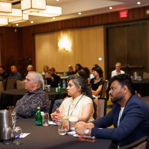 Three people seated at a round table during a conference.