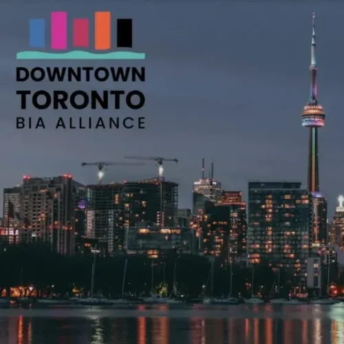 Logo for Downtown Toronto BIA Alliance over a night view of the Toronto skyline and CN Tower.