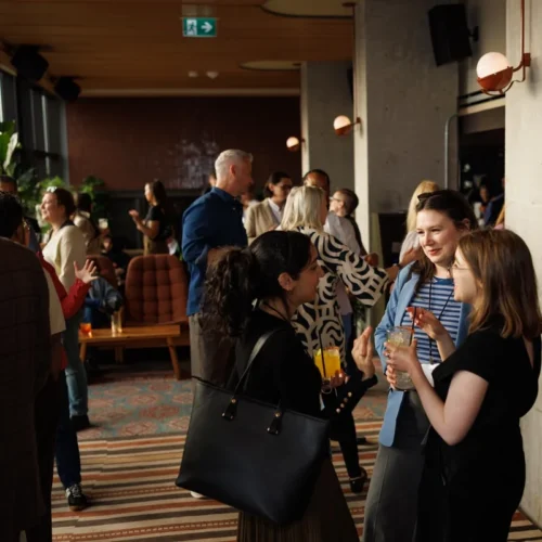 A group of people socializing with drinks at an indoor event.