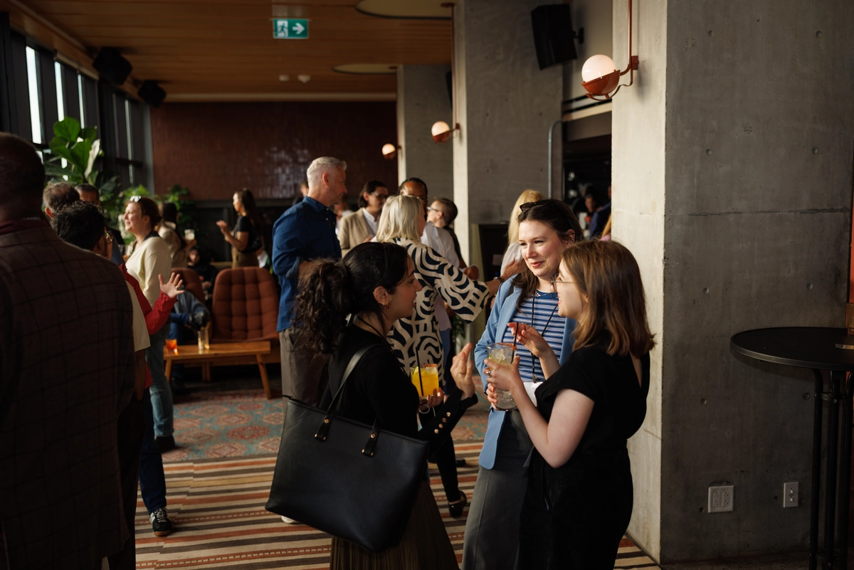 A group of people socializing with drinks at an indoor event.